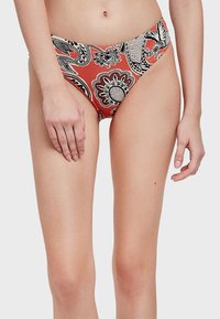 Parte inferior de bañador roja con un estampado de paisley en blanco y negro. Diseño de talle alto, fabricada con una tela suave que ofrece una silueta ajustada.