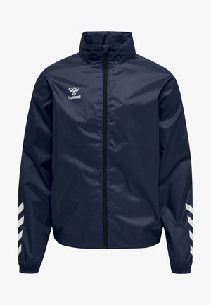 Veste de sport légère bleu marine avec fermeture éclair noire intégrale, logo hummel blanc sur la poitrine et bandes blanches en forme de chevrons sur les manches.