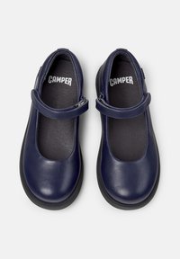 Zapatos Mary Jane de cuero azul marino con punta redonda, correa ajustable y suela de caucho negra. El interior cuenta con un forro oscuro texturizado.