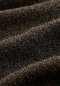 Dark brown wool fabric with a soft, fuzzy texture shown in close-up folds and gentle shadows.