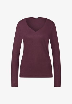 Haut pour femme à manches longues, de couleur violet profond, avec décolleté en V et coupe slim, présenté sur un fond blanc.