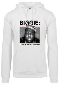 Balta kapuce ar melnbalto portretu, sarkanu robežu un tekstu: "BIGGIE: MAN IR STĀSTS, KO IZSTAĪT." Portretā ir ķēniša detaļa.