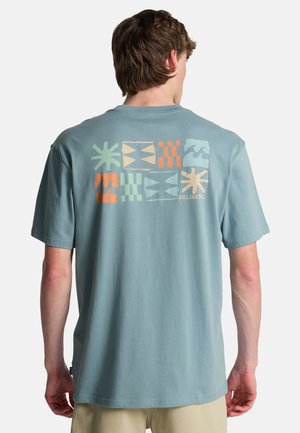 Hellblaues Baumwoll-T-Shirt mit kurzen Ärmeln, das auf der Rückseite mehrfarbige grafische Designs mit geometrischen Formen und Mustern zeigt.