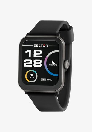 Montre intelligente noire affichant l'heure 12:28, la fréquence cardiaque 77 bpm, l'objectif de pas 12 000, et la batterie à 99 % avec un bracelet en silicone noir.