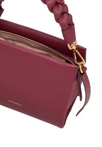 Bolso de piel burdeos con correa trenzada, cremallera dorada y un branding sutil. Textura suave con un diseño minimalista.
