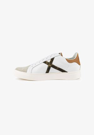 Zapatilla de cuero blanca con una punta de ante beige, un acento en el talón de cuero marrón y un patrón entrecruzado en negro y verde en el lateral.