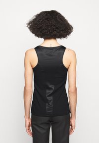 Schwarzes Tanktop mit gerippter Textur und glatten Satinakzenten, einem Rundhalsausschnitt und einem geschwungenen Rückendesign.
