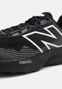 Czarne buty biegowe z teksturowaną siateczką, białymi akcentami, wyraźnym logo oraz wyściełaną czarną podeszwą opisaną jako "FUELCELL."