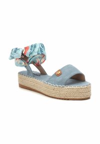 Sandal de cuña de tela azul con punta descubierta, adornada con un lazo de estampado floral alrededor del tobillo y una plataforma envuelta en yute.