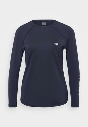 Jūras spēku garām piedurknēm krekls izgatavots no gludas auduma. Tam ir apaļš kakls, raglanu piedurknes un neliels emblema uz krūškurvja.