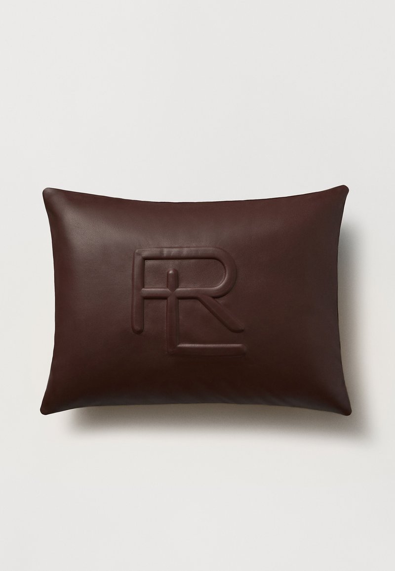 Brun läderkudde med en slät textur, med en präglad logotyp. Rektangulär form med rundade kanter, minimalistisk design.