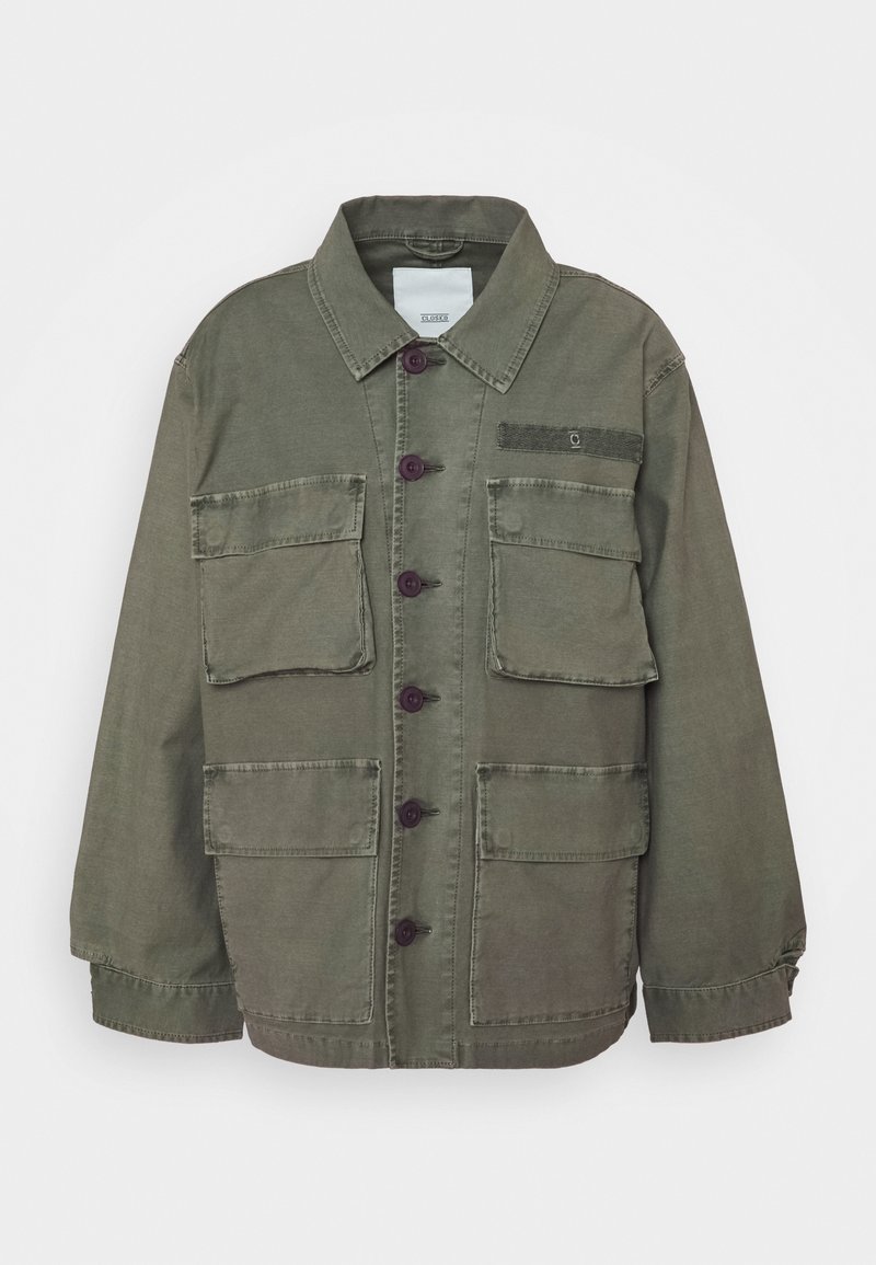 Jasnozielona kurtka zapinana na guziki z czterema przednimi kieszeniami z klapkami, kołnierzykiem i długimi rękawami, ułożona płasko na białym tle.