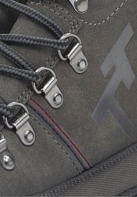 Szare zamszowe buty trekkingowe z metalowymi srebrnymi oczkami, czarnymi plecionymi sznurowadłami i wyraźnym logo. Posiadają czerwone i niebieskie zdobienia w szwach.