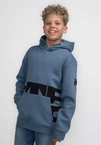 Felpa blu con tasca a marsupio e bande grafiche nere. Presenta lacci con dettagli in bianco e nero. Tessuto morbido, design casual.