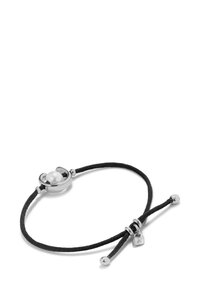 Le bracelet en cordon noir présente un fermoir en argent, un détail central en perle et des accents en perles, avec un petit charm en métal attaché.
