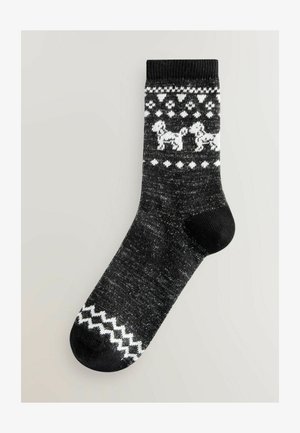 Chaussettes noires avec un motif de chien blanc, des formes de losange et des accents en zigzag. Fabriquées en matériau tricoté texturé, hauteur cheville.
