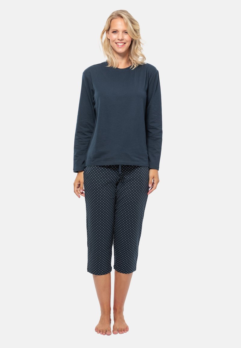 Marineblauwe longsleeve top met ronde hals, gecombineerd met cropped broeken met een wit stippenpatroon. Gemaakt van zachte stof.
