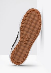 Suela de zapatilla negra con goma texturizada; incluye una media suela de espuma blanca y una marca visible. Diseño contorneado para tracción y comodidad.