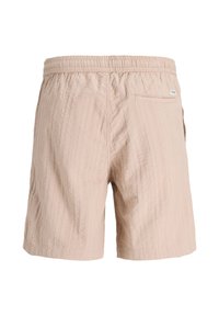 Bež kratke hlače s teksturom, elastičnim pojasom i jednim stražnjim džepom, prikazane s stražnje strane.