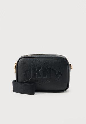 Sac bandoulière rectangulaire en cuir noir avec le logo « DKNY New York » embossé sur le devant, équipé d'une fermeture éclair dorée et d'une large sangle en tissu.