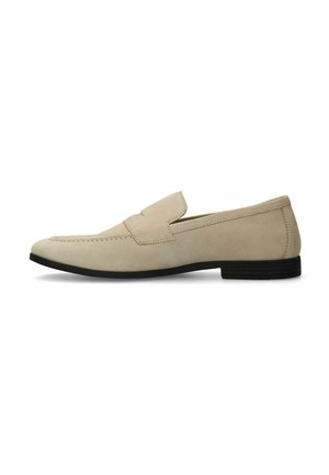 Beige suede loafers with a flat black rubber sole, featuring a stitched front seam and a rounded toe design without laces.
