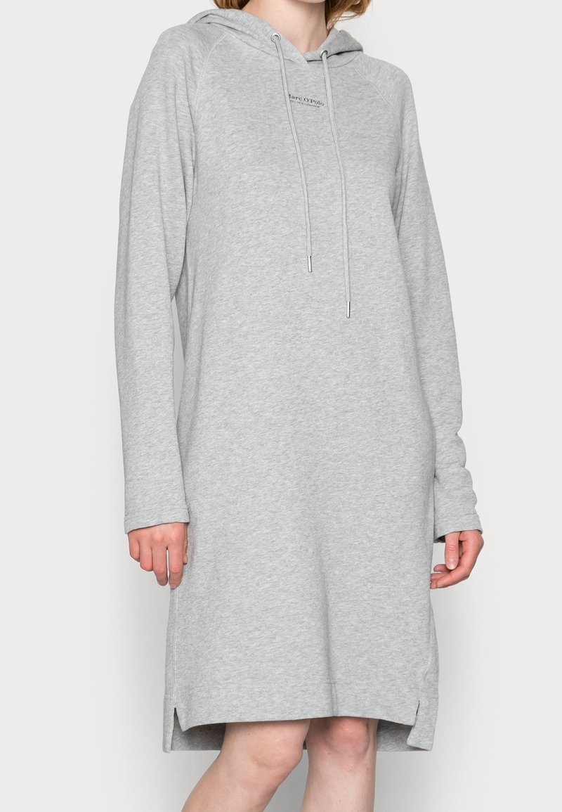 Robe sweat à capuche gris clair en tissu doux, avec cordon de serrage et fentes latérales pour faciliter les mouvements.