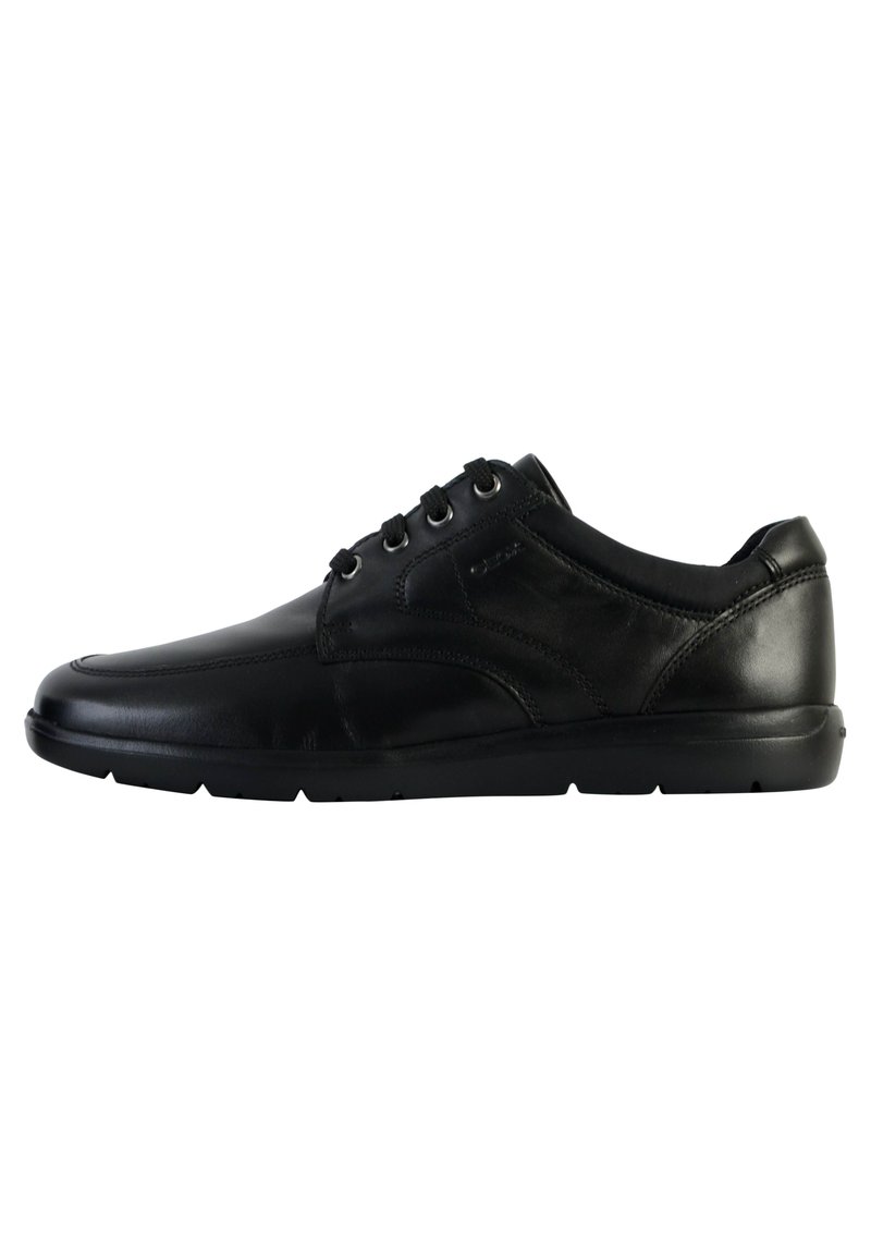Sneaker in pelle nera con profilo basso, punta arrotondata, chiusura con lacci e dettagli testurizzati sui lati e sul tallone.