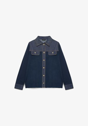 Denim jacket with a dark blue body, lighter denim yoke and pocket flaps, studded collar, and button closure. Ribbed cuffs and hem.