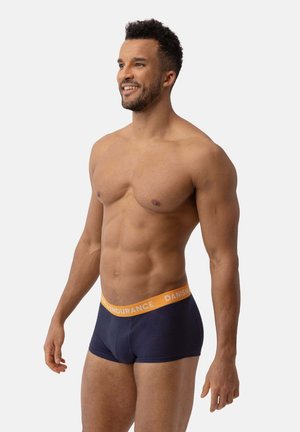 Mörkblå boxerkalsonger med en orange elastisk midjeband som har texten "DANISH ENDURANCE". Slät tygkvalitet, åtsittande design och med längd till mitten av låret.