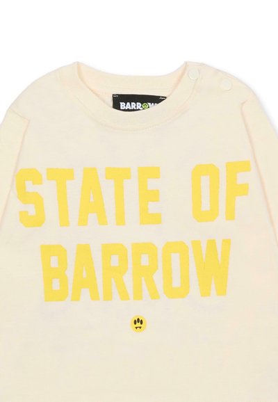 Felpa color crema con grande scritta gialla "STATE OF BARROW" e un piccolo logo smiley nero. Chiusura a scatto sulla spalla.
