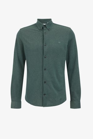 Chemise boutonnée vert foncé à manches longues, avec col, boutons noirs, et une texture subtile. Présente un petit logo brodé sur la poitrine.