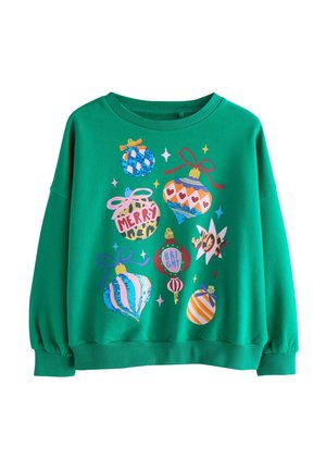 Zielona bluza ozdobiona kolorowymi świątecznymi ozdobami, w tym zawieszkami z napisami "WESOŁYCH", "RADOSNYCH" i "SZALEŃSTWA" oraz różnymi kokardami.