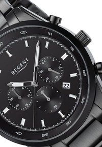 Montre chronographe noire avec accents argentés, trois sous-cadrans, affichage de la date et bracelet en acier inoxydable. Présente des index horaires audacieux et un cadran texturé.