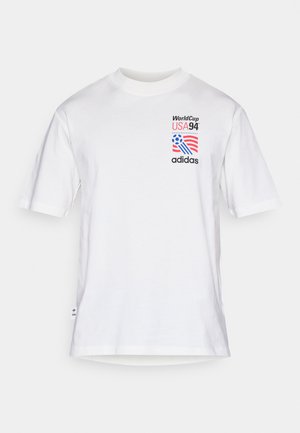 Hvid bomulds t-shirt med korte ærmer, rund halsudskæring og trykt grafik med "WorldCup USA 94" og "adidas" i sort, rød og blå.