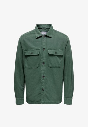 Chaqueta de camisas de algodón verde con cuello, dos bolsillos en el pecho, cierre frontal con botones y mangas largas. Presenta botones negros y un acabado texturizado.
