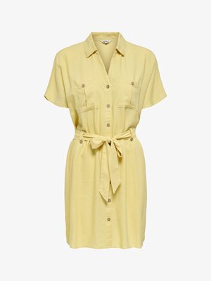 Kratka rumena obleka s kratkimi rokavi, dvema žepoma na prsih ter pasom, ki se veže vpasu.