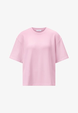 Svetloružové oversized tričko s krátkym rukávom, okrúhlym výstrihom a viditeľnými švami na pleciach a rukávoch.