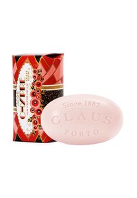 Rose-colored oval soap labeled "Claus Porto" with a decorative, red and black patterned box featuring floral accents and golden bands.