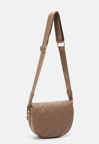 Barna bőr válltáska steppelt mintázattal, kerekített formával, arany kiegészítőkkel és márkázott szövetpánttal. Oldalán cipzáras záródás.