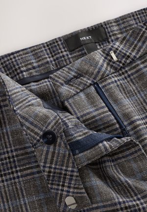 Bukser lavet af gråt hundetandsmønsterstof med blå og sorte tern. Har lynlåslomme, knaplukning og vævet label.