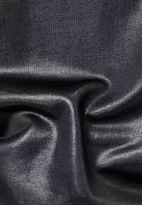 Svart, texturerad tyg med en slät, reflekterande yta som visar subtila vågor och veck, vilket framhäver dess tänjbarhet och glans.