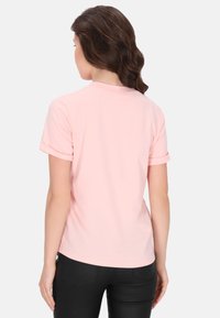 Tricou din bumbac roz deschis, cu mâneci scurte răsucite, guler rotund și o textură netedă, văzut din spate.