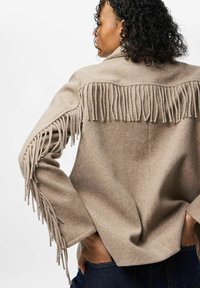 Beez villane jakk frantsiiside detailidega selja ja varrukate ääres. Omab lõdva lõiget, laiad varrukad ja sujuvat tekstuuri.