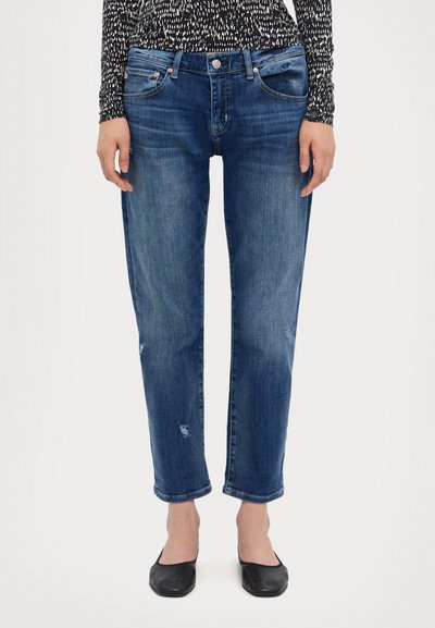 Jeans din denim albastru cu o croială relaxată, având talie medie, ușoare uzuri și margini manșonate. Asociați cu pantofi negri de tip plat.