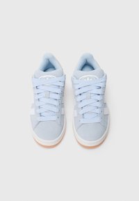 Světle modré tenisky s horní částí z broušené kůže, bílými pruhy a odpovídajícími tkaničkami. Mají zaoblenou špičku a opáleně hnědou pryžovou podešev.