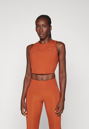 Korte sporttop in roest-oranje met een zachte textuur, gecombineerd met bijpassende hooggetailleerde legging, beide gemaakt van rekbaar stof.