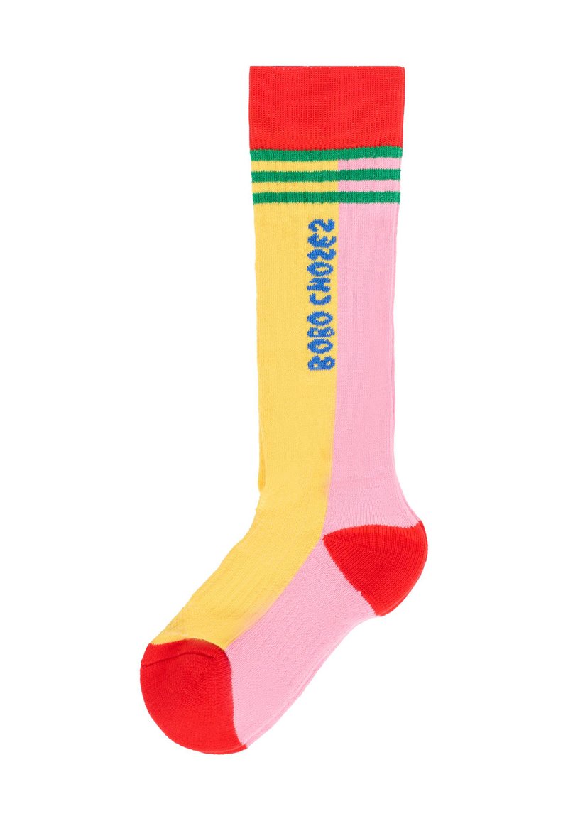 Calza lunga fin sopra il ginocchio con parte superiore rossa, sezioni gialle e rosa, e accenti a righe verdi. Motivo testuale blu nell'area gialla. Materiale in cotone.