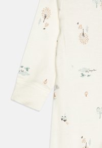 Kreemivärvi kangas, millel on puude, loomade ja pilvede muster vaigistatud rohelise ja oranžiga, pehme tekstuuriga ja elastsete mansettidega.