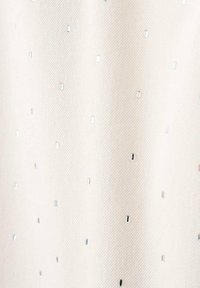 Tejido con una superficie texturada de un color crema claro decorada con pequeños acentos metálicos cuadrados y brillantes distribuidos uniformemente por toda la tela.
