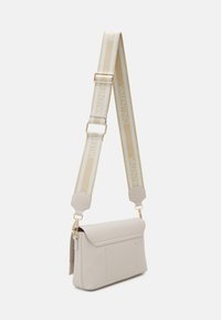 Beige leather crossbody bag with a fold-over flap, gold hardware, and a cream and beige striped adjustable strap featuring "VALENTINO" logo.